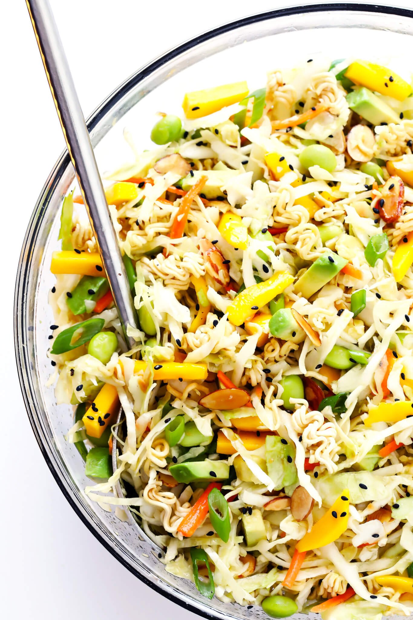 This Crunchy Asian Ramen Noodle Salad is easy to make, tossed with fresh mango, avocado, edamame, cole slaw, almonds, and a sesame honey vinaigrette...and SO delicious! Perfect for potlucks, picnics, or as a simple salad or side dish. | gimmesomeoven.com