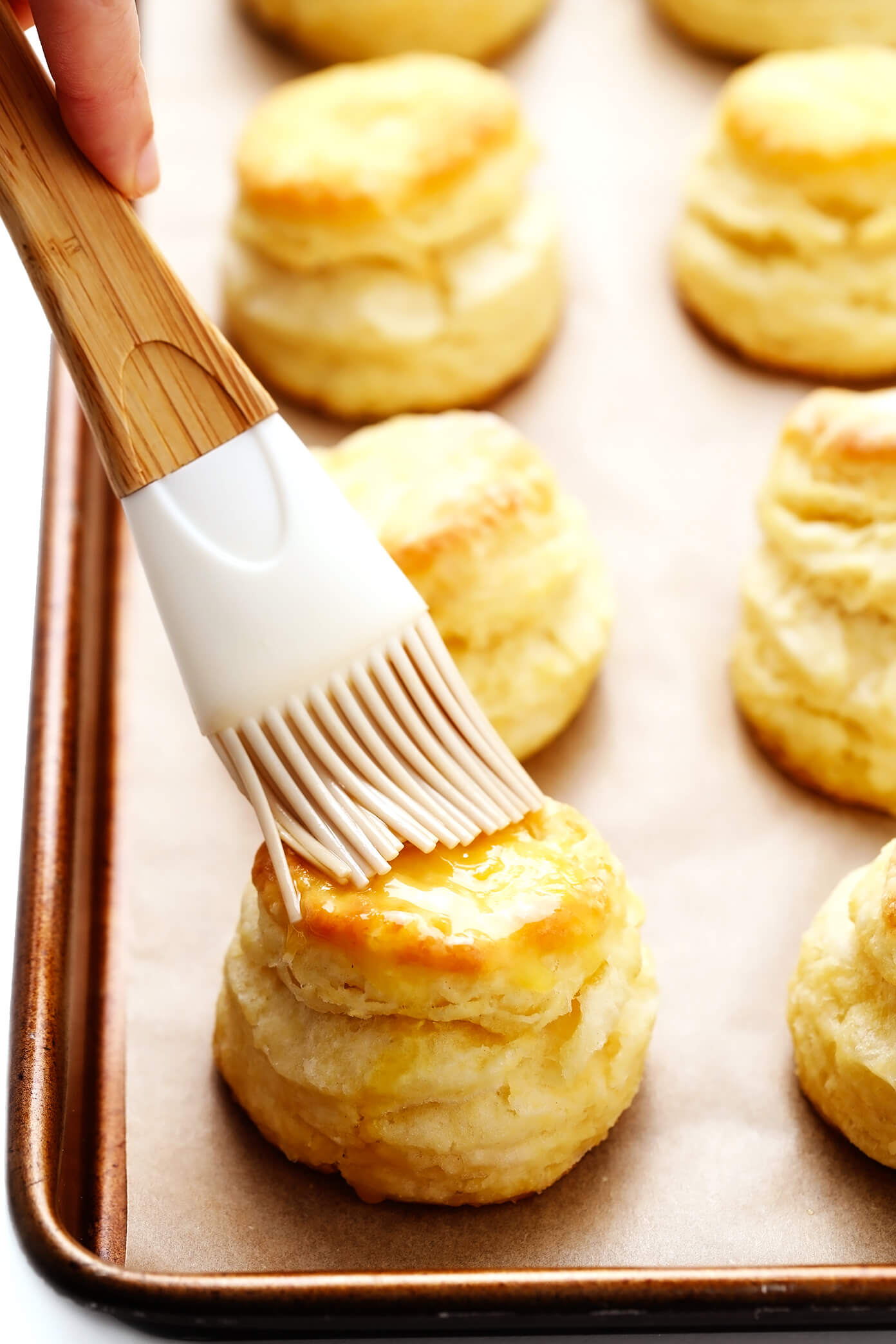 Brushing butter on homemade biscuits