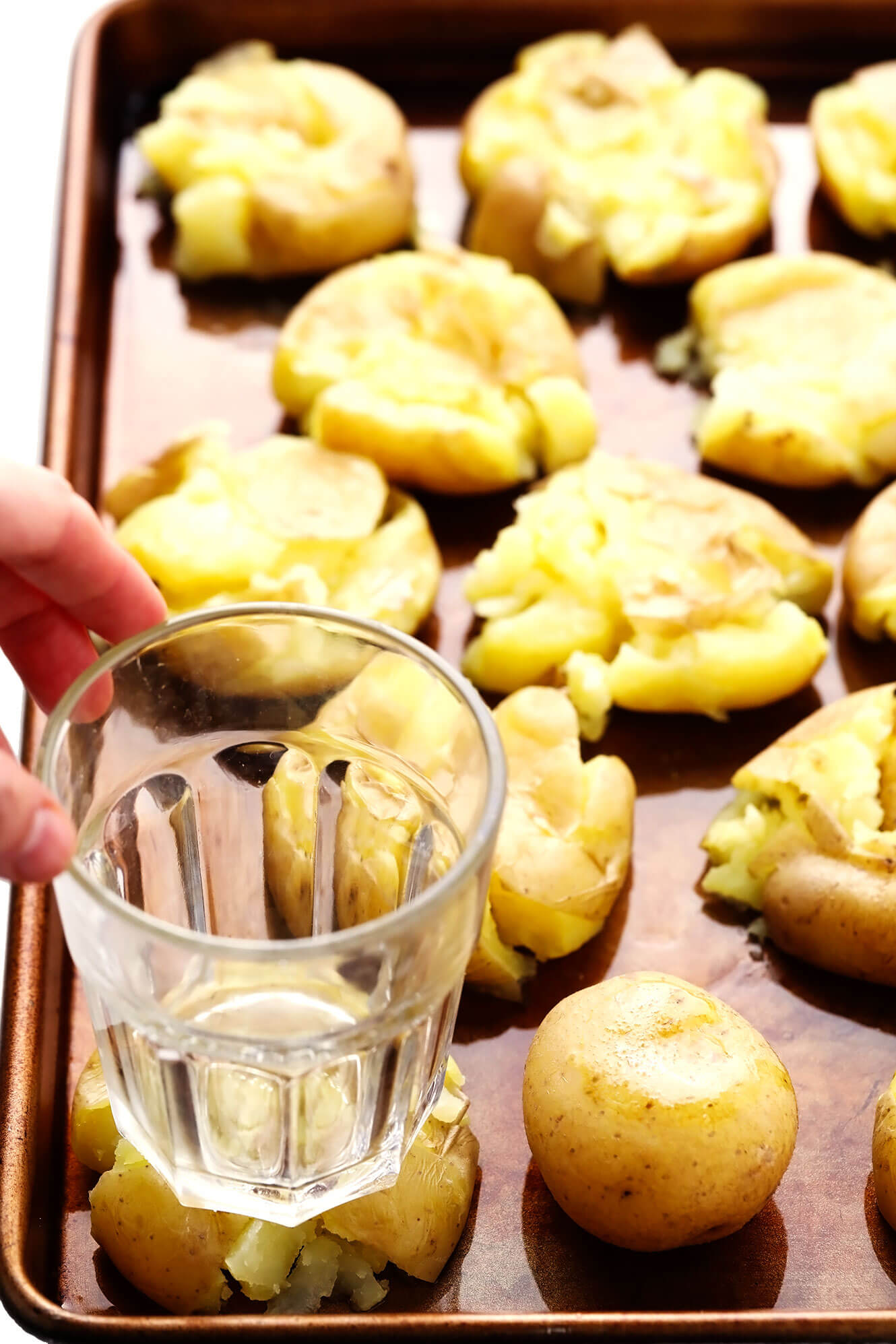 Smashing boiled potatoes with a drinking glass
