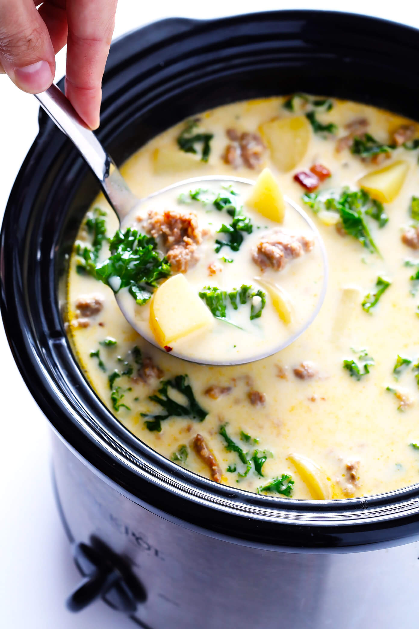 Learn how to make this favorite Olive Garden soup on the stovetop or in the slow cooker! This Zuppa Toscana recipe is super easy to make, naturally gluten-free, and full of the most delicious zesty, creamy flavors. So grab some Italian sausage, kale, potatoes, bacon, Parmesan, and garlic, and make it happen! Crock-pot instructions also included.