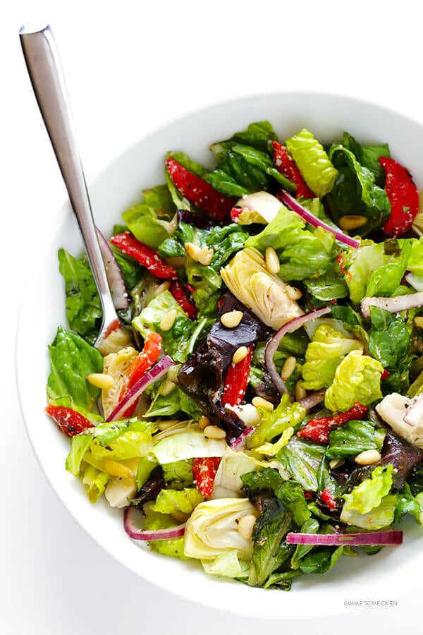 Our Family's Favorite Salad is made with lots of artichoke hearts, roasted red peppers, toasted pine nuts, and a zesty Parmesan vinaigrette. SO delicious, and always a crowd pleaser! | gimmesomeoven.com