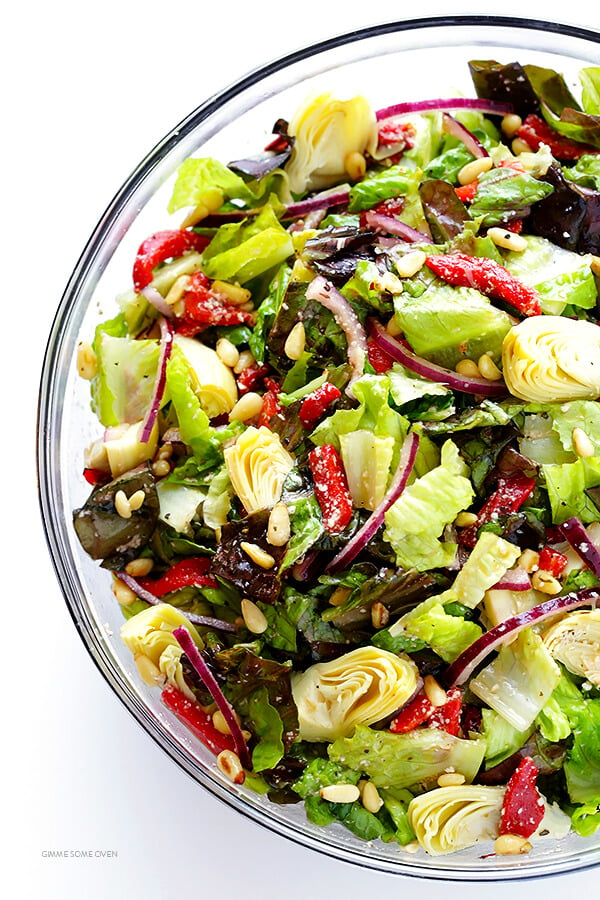 Our Family's Favorite Salad is made with lots of artichoke hearts, roasted red peppers, toasted pine nuts, and a zesty Parmesan vinaigrette. SO delicious, and always a crowd pleaser! | gimmesomeoven.com