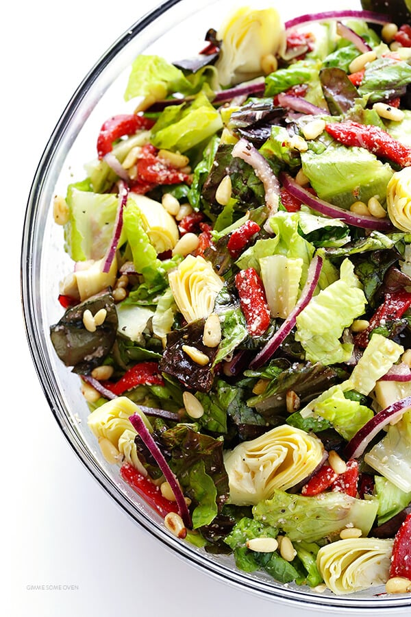 Our Family's Favorite Salad is made with lots of artichoke hearts, roasted red peppers, toasted pine nuts, and a zesty Parmesan vinaigrette. SO delicious, and always a crowd pleaser! | gimmesomeoven.com