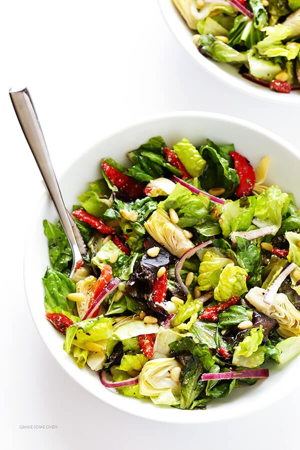 Our Family's Favorite Salad is made with lots of artichoke hearts, roasted red peppers, toasted pine nuts, and a zesty Parmesan vinaigrette. SO delicious, and always a crowd pleaser! | gimmesomeoven.com