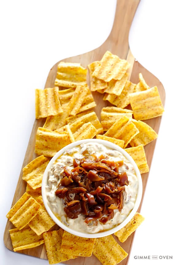 skinny french onion dip in a bowl on a cutting board with sun chips