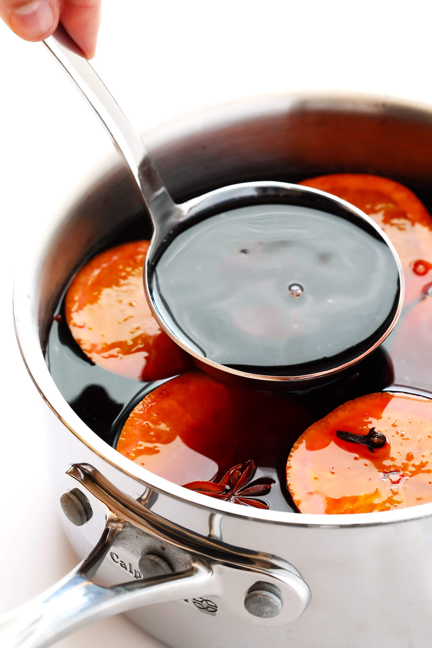 Ladle of mulled wine with oranges