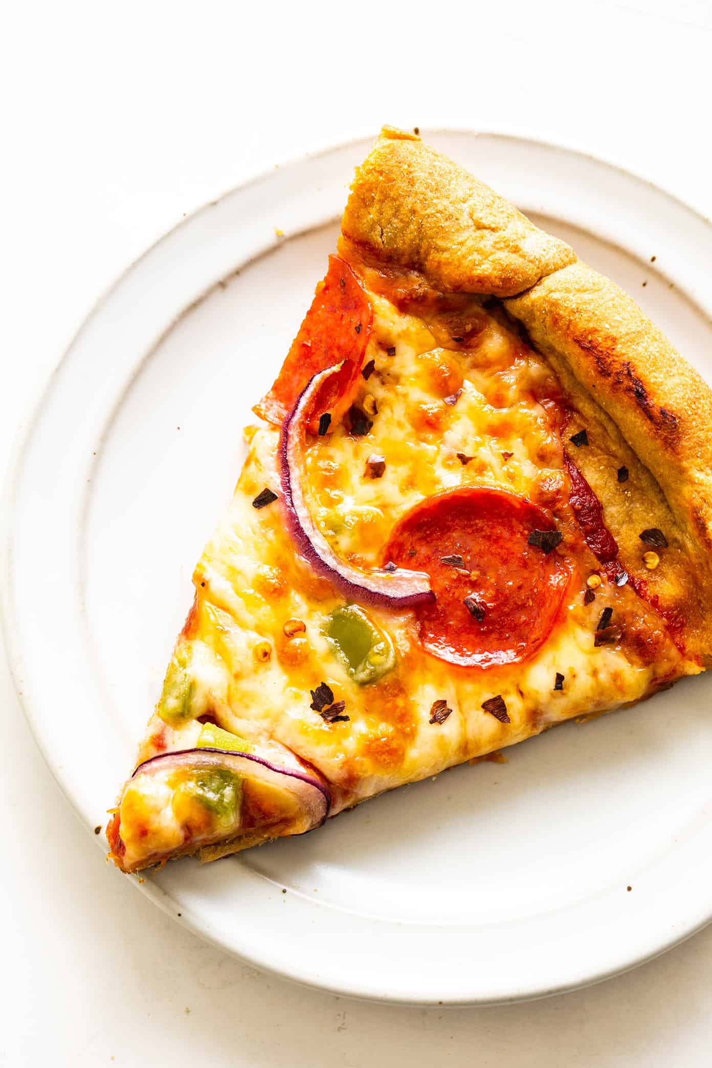 Slice of homemade pizza with whole wheat dough on plate