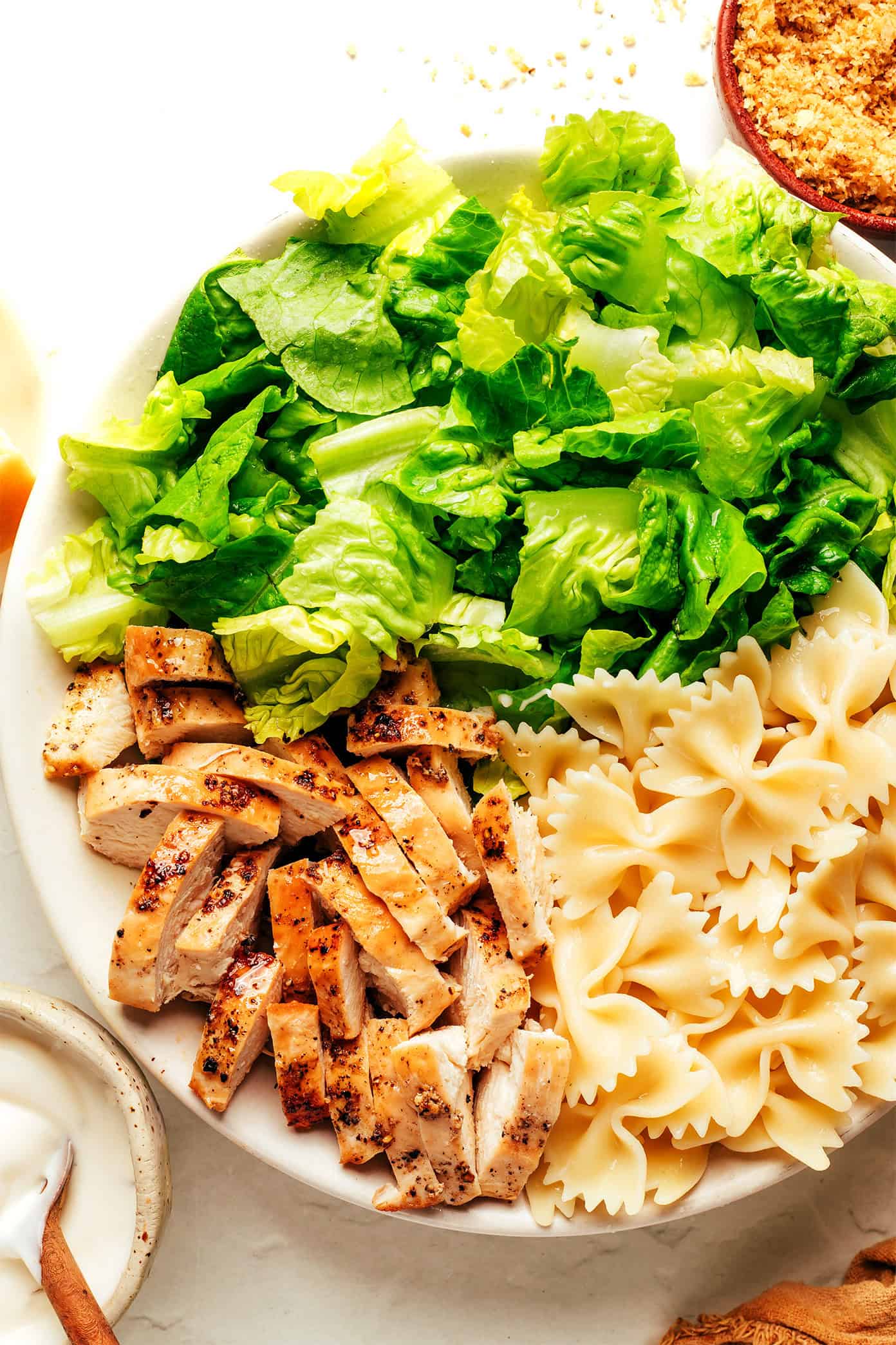 Chicken caesar pasta salad ingredients in bowl
