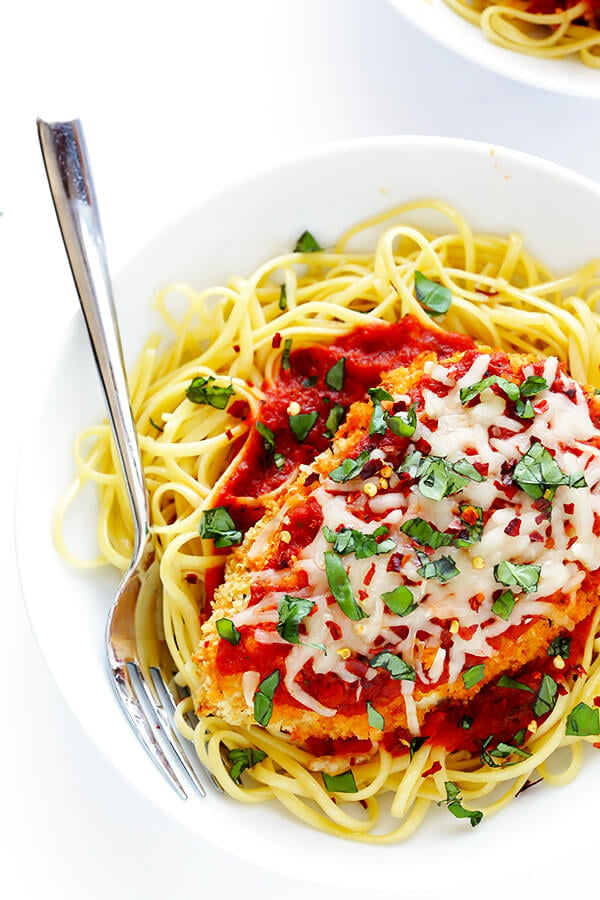 This Spicy Baked Chicken Parmesan recipe is made with a crispy seasoned panko crust, and topped with a spicy marinara sauce, melted mozzarella, and lots of fresh basil. It's surprisingly simple to make, and SO delicious! | gimmesomeoven.com
