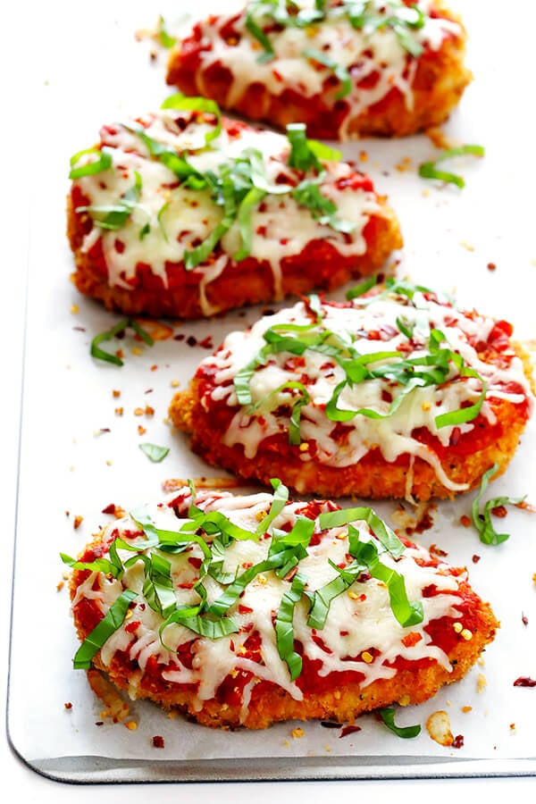 This Spicy Baked Chicken Parmesan recipe is made with a crispy seasoned panko crust, and topped with a spicy marinara sauce, melted mozzarella, and lots of fresh basil. It's surprisingly simple to make, and SO delicious! | gimmesomeoven.com