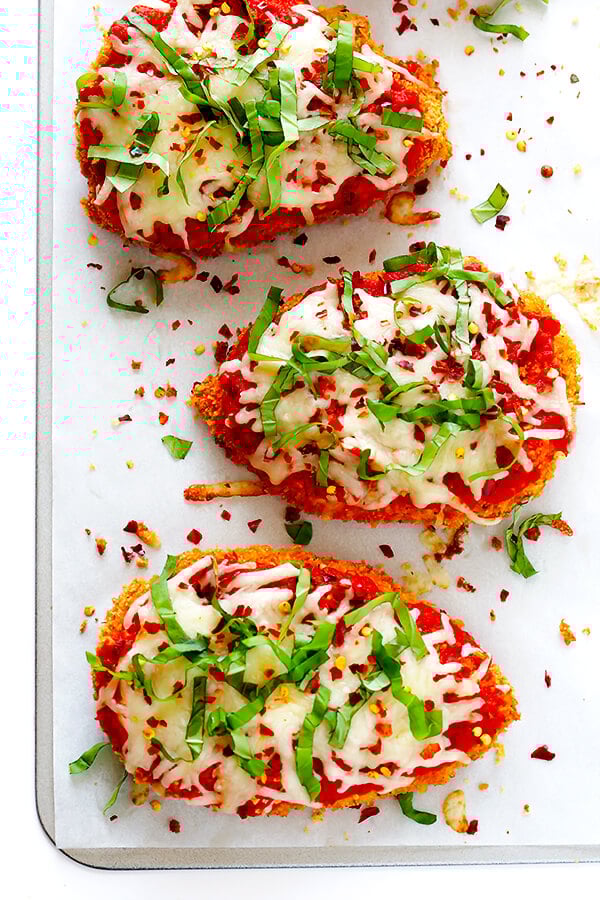 This Spicy Baked Chicken Parmesan recipe is made with a crispy seasoned panko crust, and topped with a spicy marinara sauce, melted mozzarella, and lots of fresh basil. It's surprisingly simple to make, and SO delicious! | gimmesomeoven.com