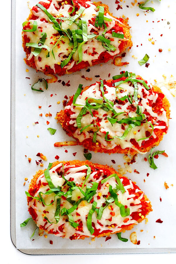 This Spicy Baked Chicken Parmesan recipe is made with a crispy seasoned panko crust, and topped with a spicy marinara sauce, melted mozzarella, and lots of fresh basil. It's surprisingly simple to make, and SO delicious! | gimmesomeoven.com