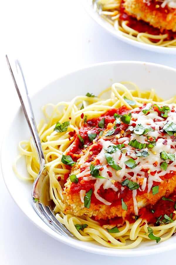 This Spicy Baked Chicken Parmesan recipe is made with a crispy seasoned panko crust, and topped with a spicy marinara sauce, melted mozzarella, and lots of fresh basil. It's surprisingly simple to make, and SO delicious! | gimmesomeoven.com