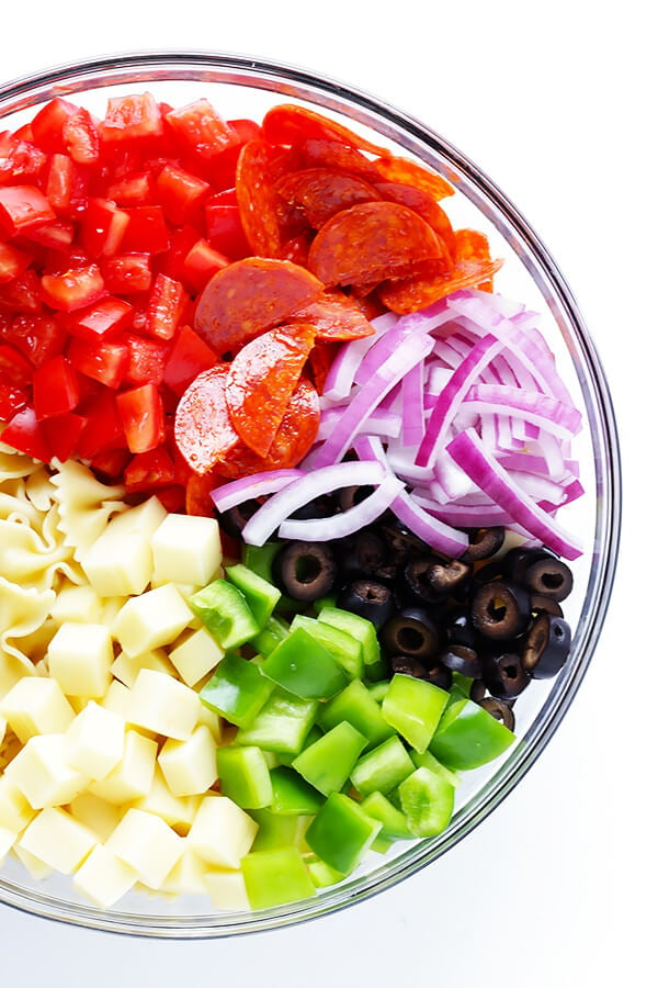 This Pizza Pasta Salad recipe is quick and easy to make, it's tossed with a simple Italian vinaigrette, and you can customize it with all of your favorite pizza toppings! | gimmesomeoven.com