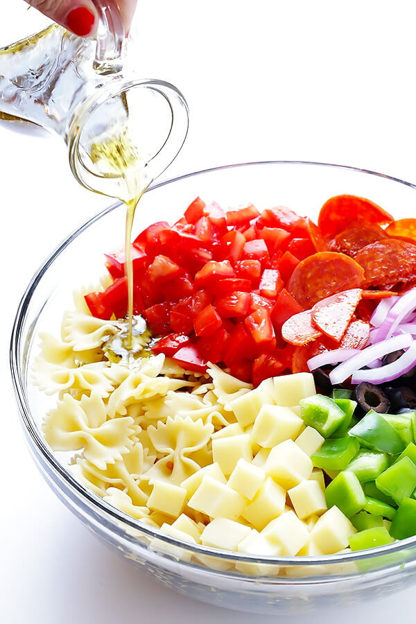 This Pizza Pasta Salad recipe is quick and easy to make, it's tossed with a simple Italian vinaigrette, and you can customize it with all of your favorite pizza toppings! | gimmesomeoven.com