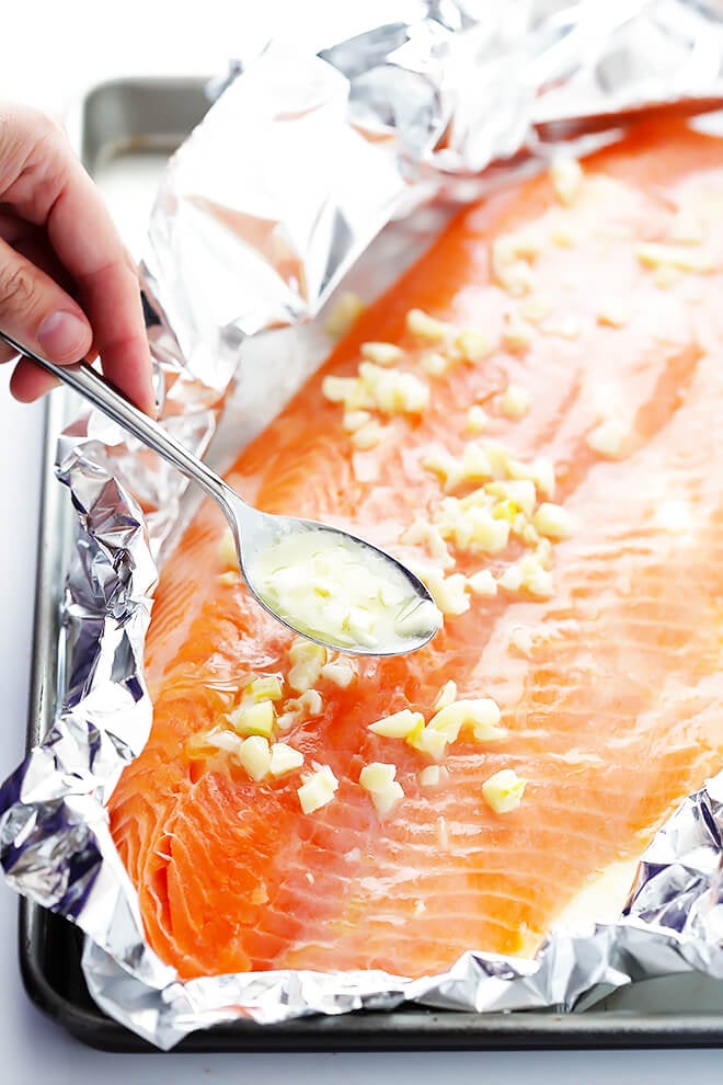 This Garlic Lovers Salmon In Foil recipe only takes a few minutes to prep, it's made with a SUPER delicious lemon garlic butter sauce, and it's always a crowd pleaser! Directions included for how cook it on the grill or in the oven. | gimmesomeoven.com