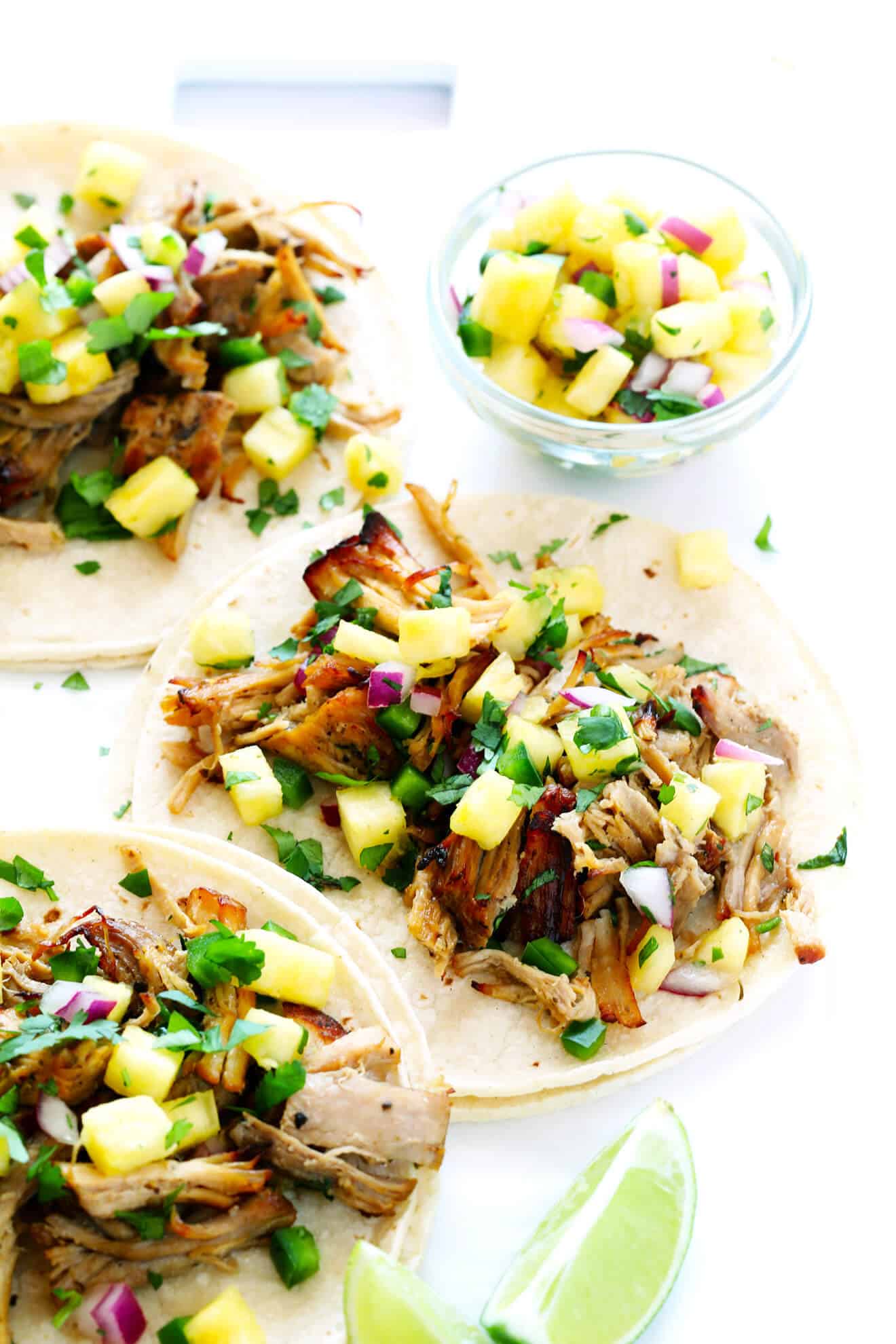 These tasty Instant Pot Carnitas are tossed with a pineapple salsa, and marinade with a delicious citrus mojo sauce! | gimmesomeoven.com