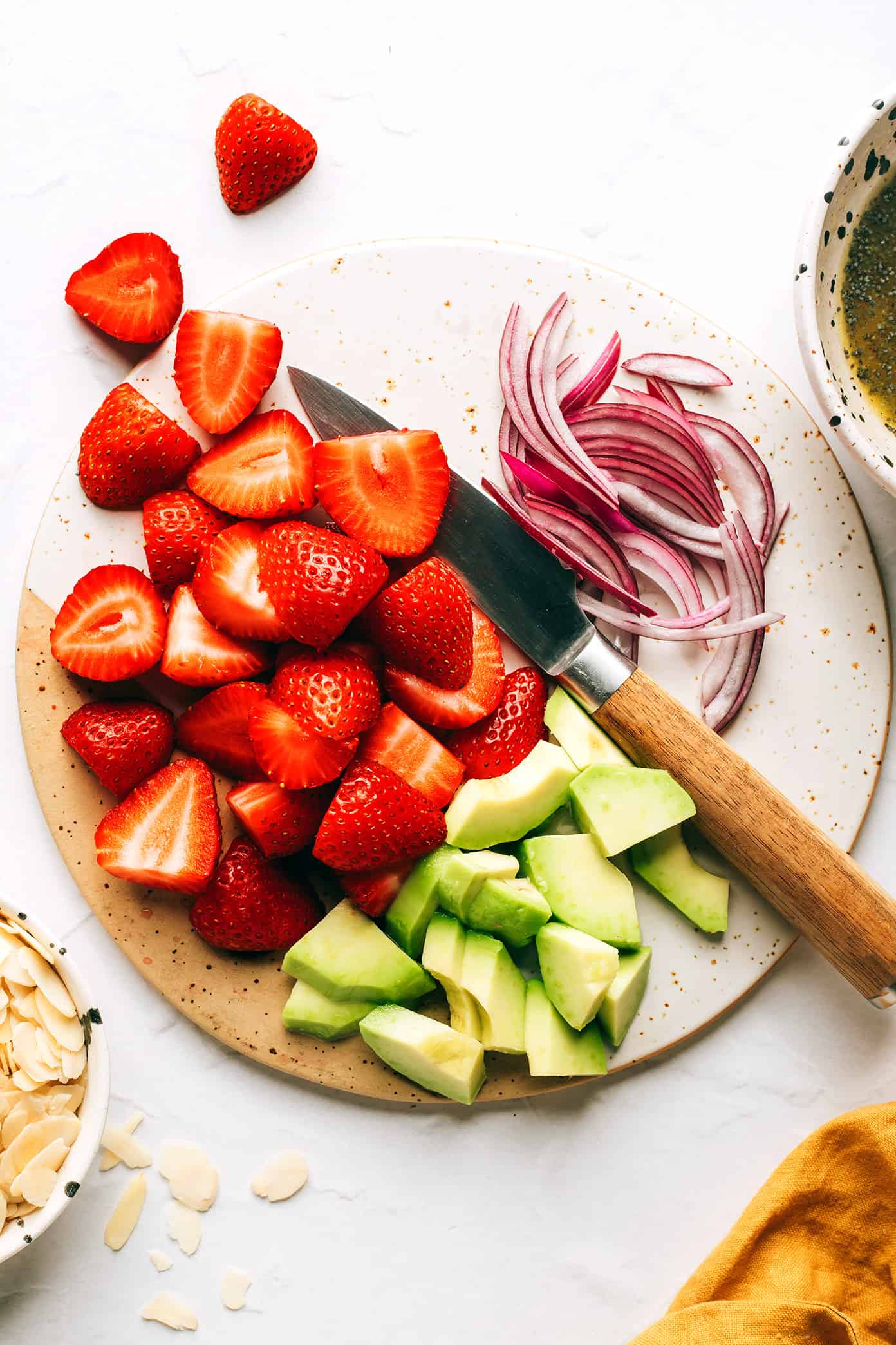 Slicing strawberries, avocado and red onion