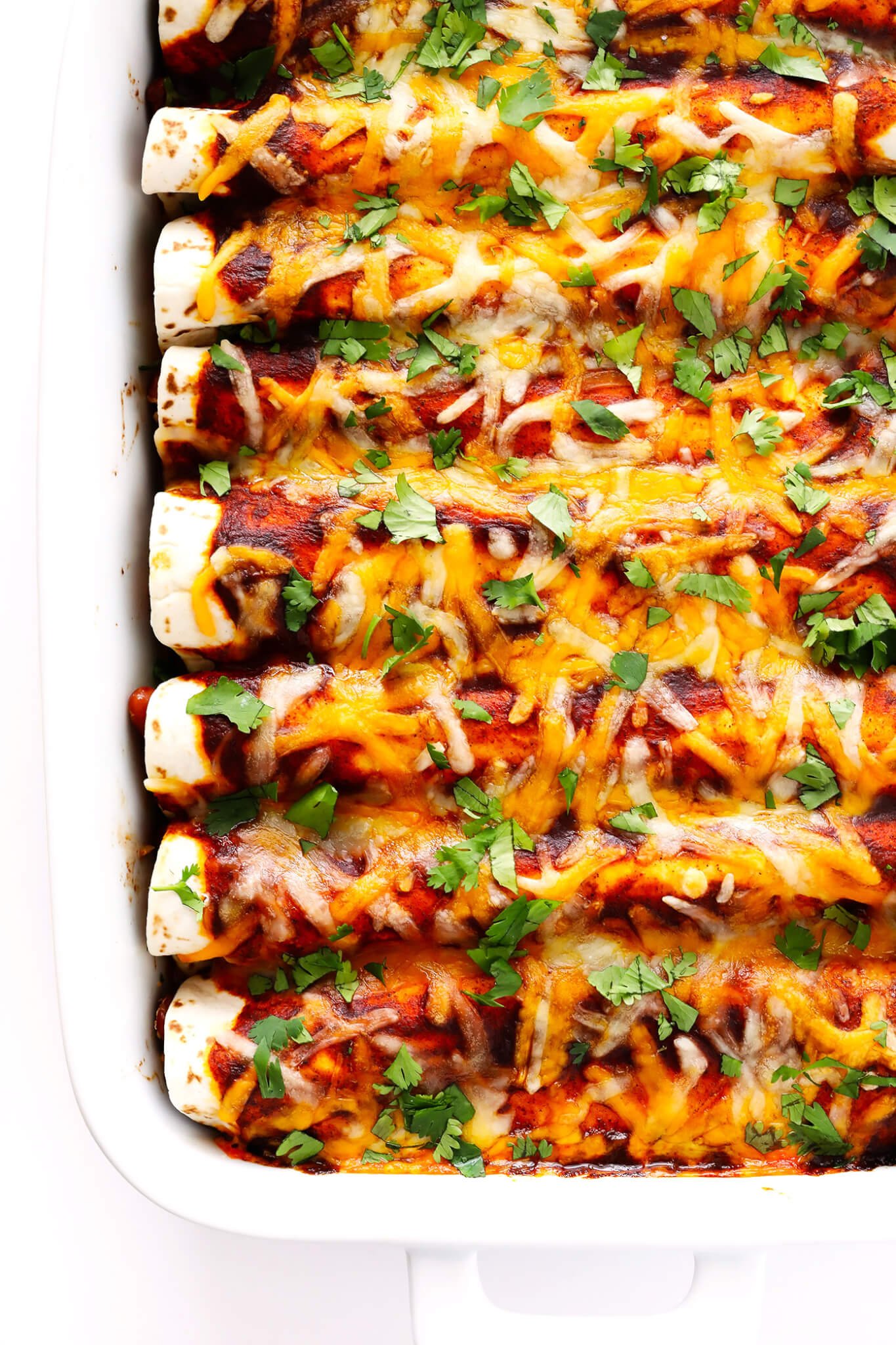 This Ancho Chicken Enchiladas recipe is easy to make, full of big flavor, nice and cheesy and filled with chicken and beans, and perfect for Cinco de Mayo or anytime you're feeling like Mexican food! | gimmesomeoven.com