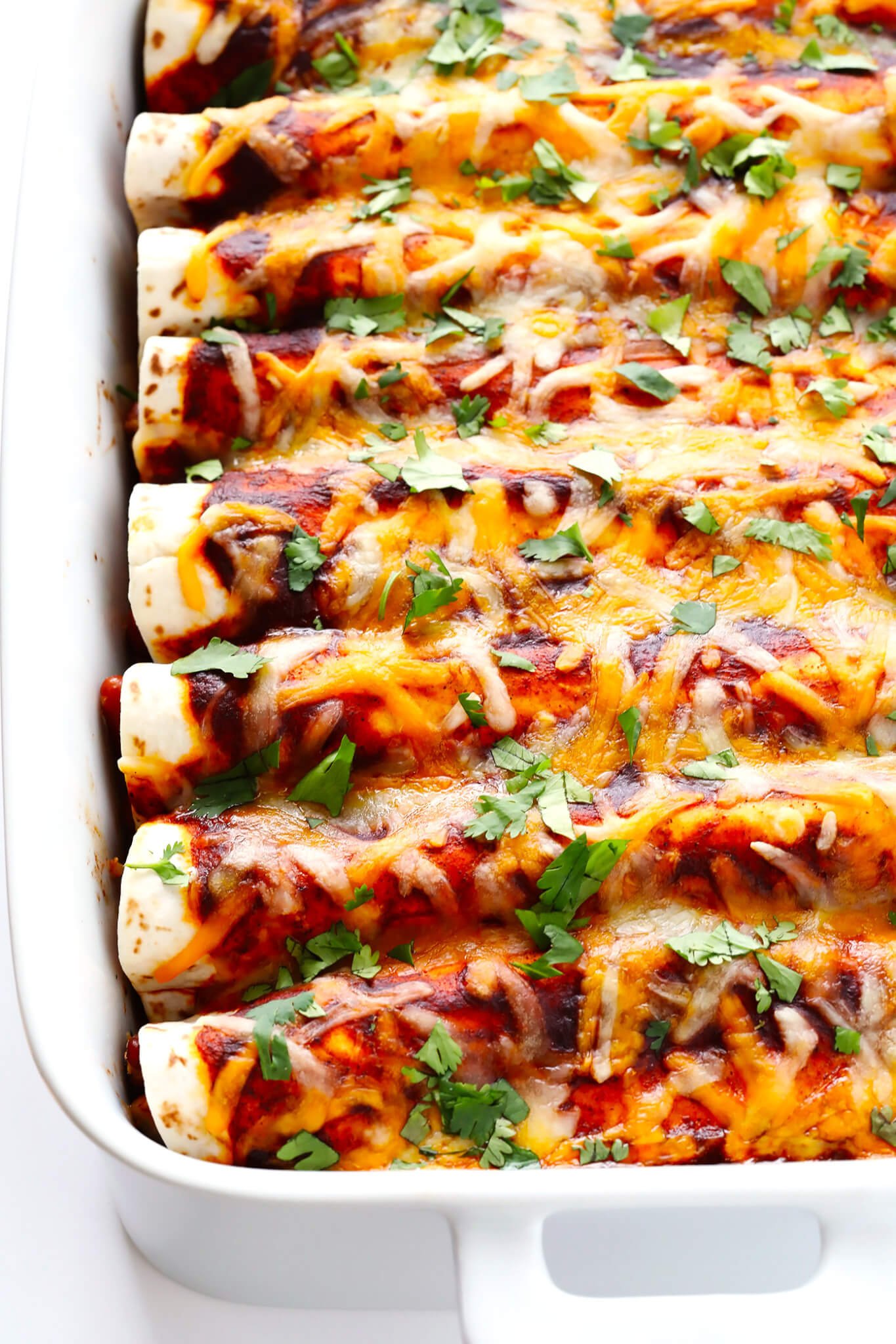 This Ancho Chicken Enchiladas recipe is easy to make, full of big flavor, nice and cheesy and filled with chicken and beans, and perfect for Cinco de Mayo or anytime you're feeling like Mexican food! | gimmesomeoven.com