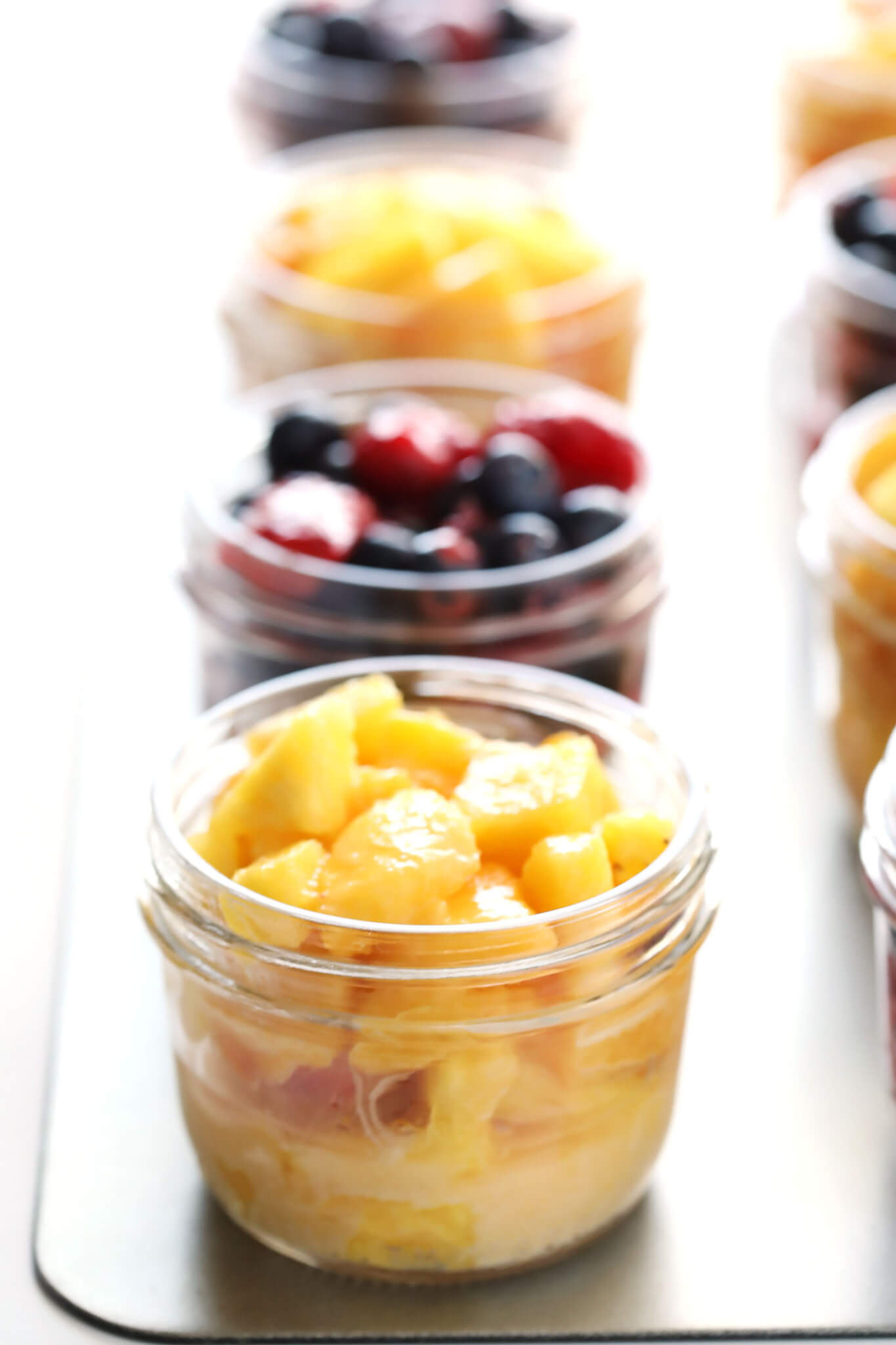 These delicious Mini Mason Jar Fruit Crisps can be made with your favorite seasonal fruit (peaches, berries, apples, pineapple, you choose!), and topped with a delicious oatmeal-almond crumble. A quick and easy and DELICIOUS dessert! | gimmesomeoven.com