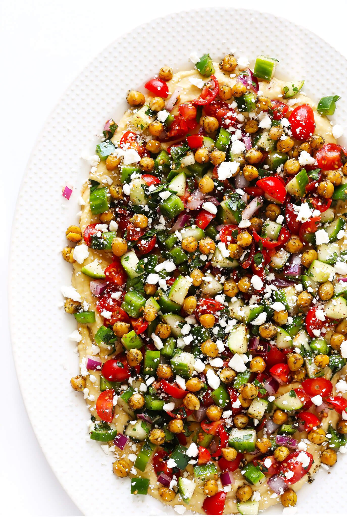 This delicious Israeli Salad recipe is quick and easy to make, full of the fresh flavors of tomatoes, cucumbers, peppers, mint, parsley and sumac, and it's so delicious! Serve it up on its own, or use it to make a simple pita wrap or hummus dip! | gimmesomeoven.com