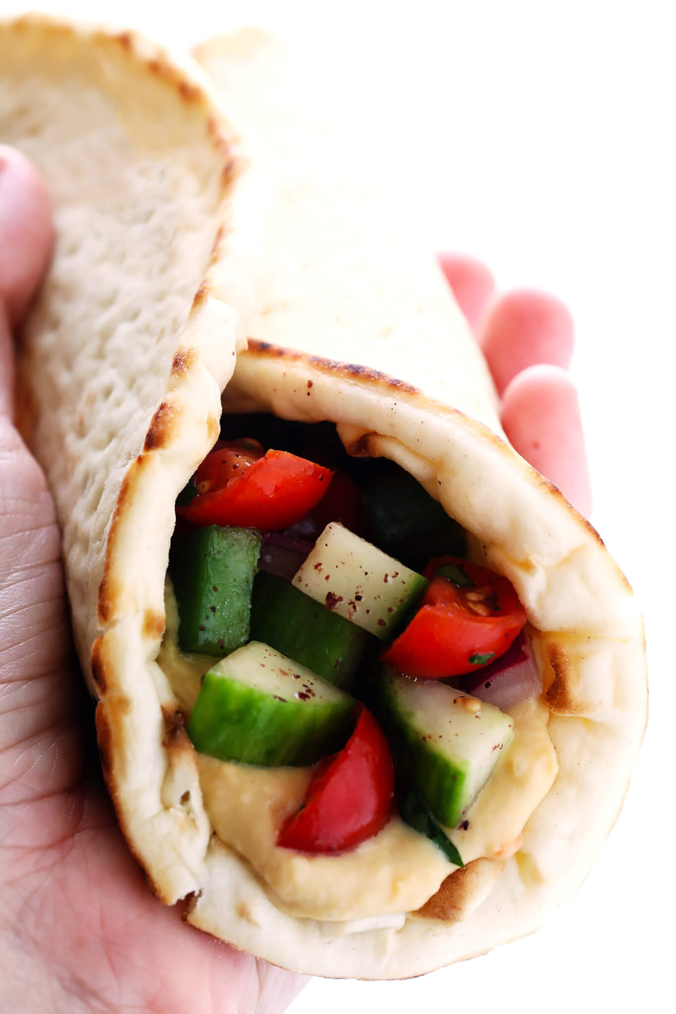 This delicious Israeli Salad recipe is quick and easy to make, full of the fresh flavors of tomatoes, cucumbers, peppers, mint, parsley and sumac, and it's so delicious! Serve it up on its own, or use it to make a simple pita wrap or hummus dip! | gimmesomeoven.com