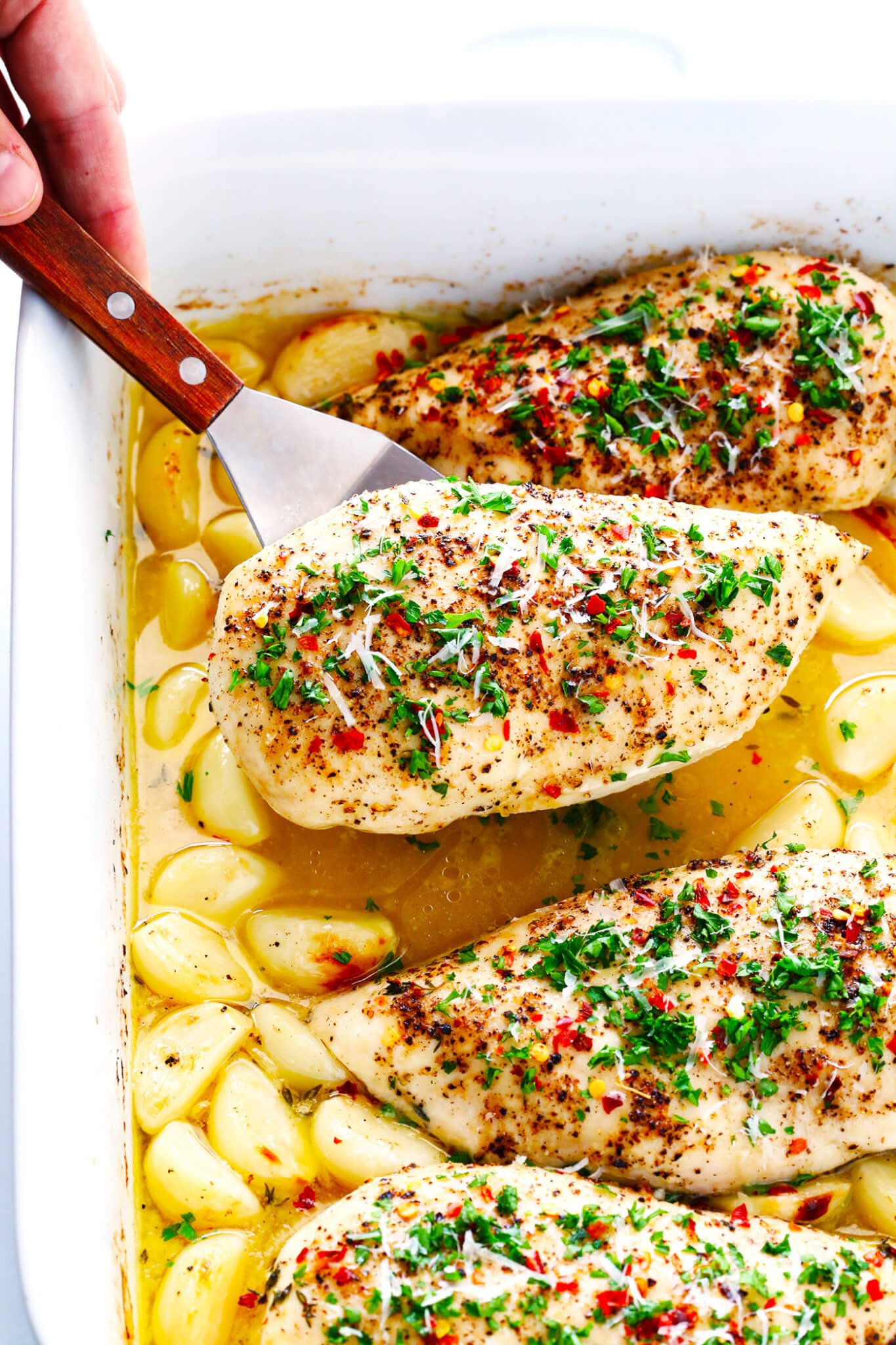 This Garlic Lovers Baked Chicken recipe is quick and easy to prepare, it's baked in the oven with a delicious lemon-butter sauce, and it's made with 40 cloves of garlic that are roasted to perfection. It's also naturally gluten-free, and SO delicious. An awesome weeknight dinner idea!