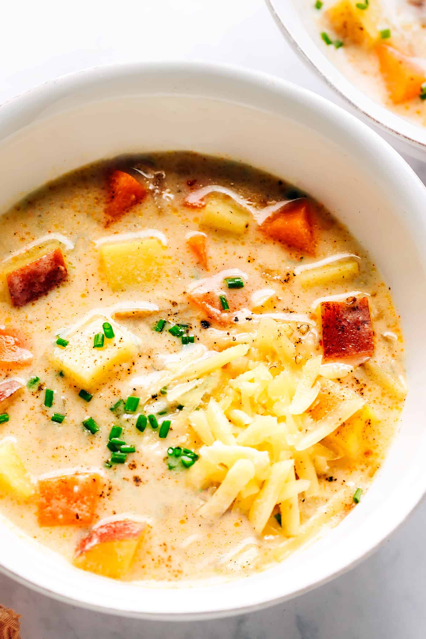 Bowl of three potato soup with cheddar and chives