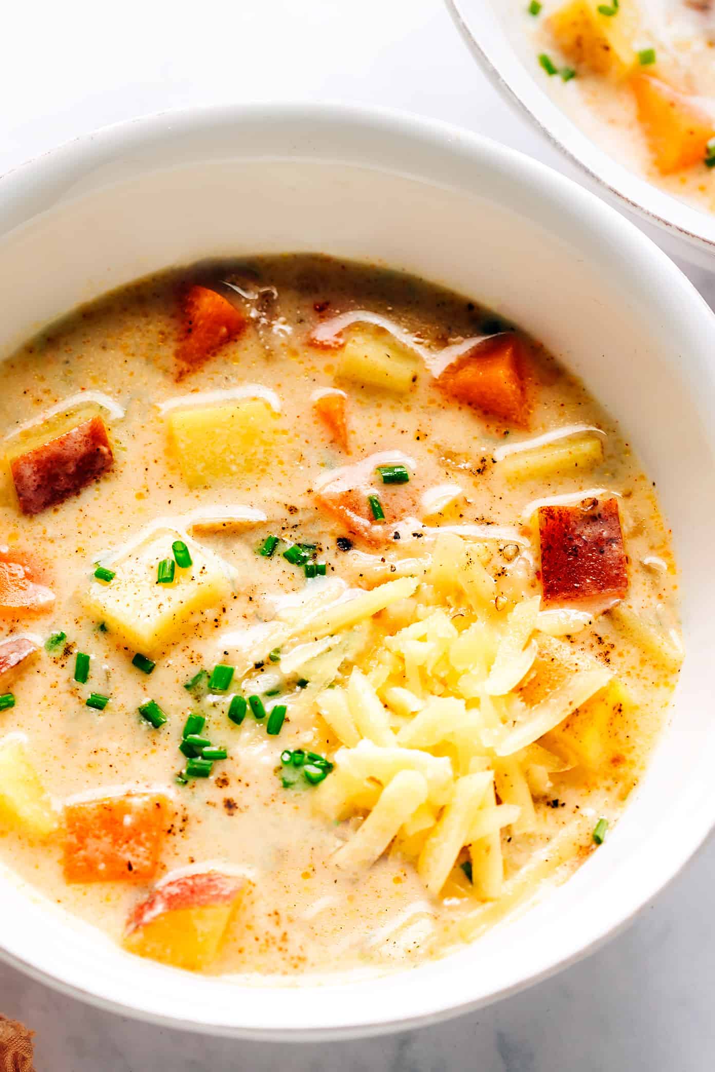 Tigela de sopa de três batatas com cheddar e cebolinha