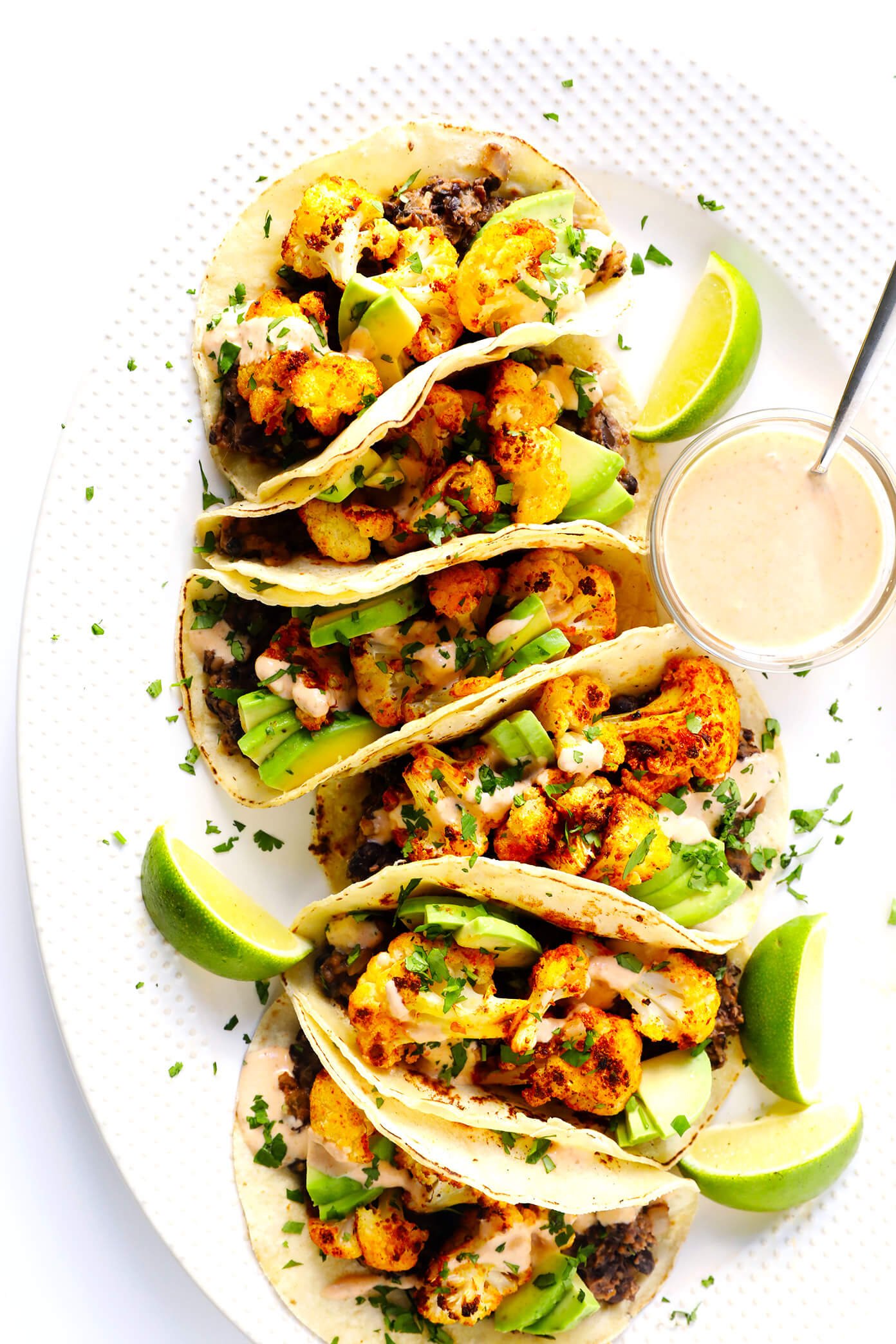 http://www.beincooking.com/ These Roasted Cauliflower and Black Bean Tacos are naturally vegetarian, vegan and gluten-free, they're topped with avocado, cilantro, and a zesty cumin lime crema, and they are SO delicious! | Gimme Some Oven #cauliflowertacos #tacorecipe #vegetarianrecipe #glutenfreerecipe