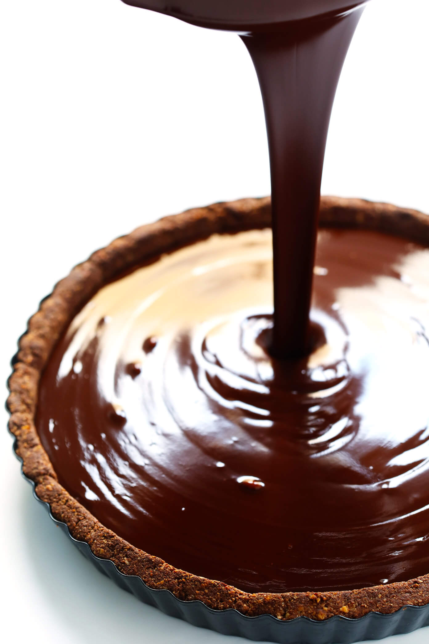 Pouring dark chocolate filling into tart pan