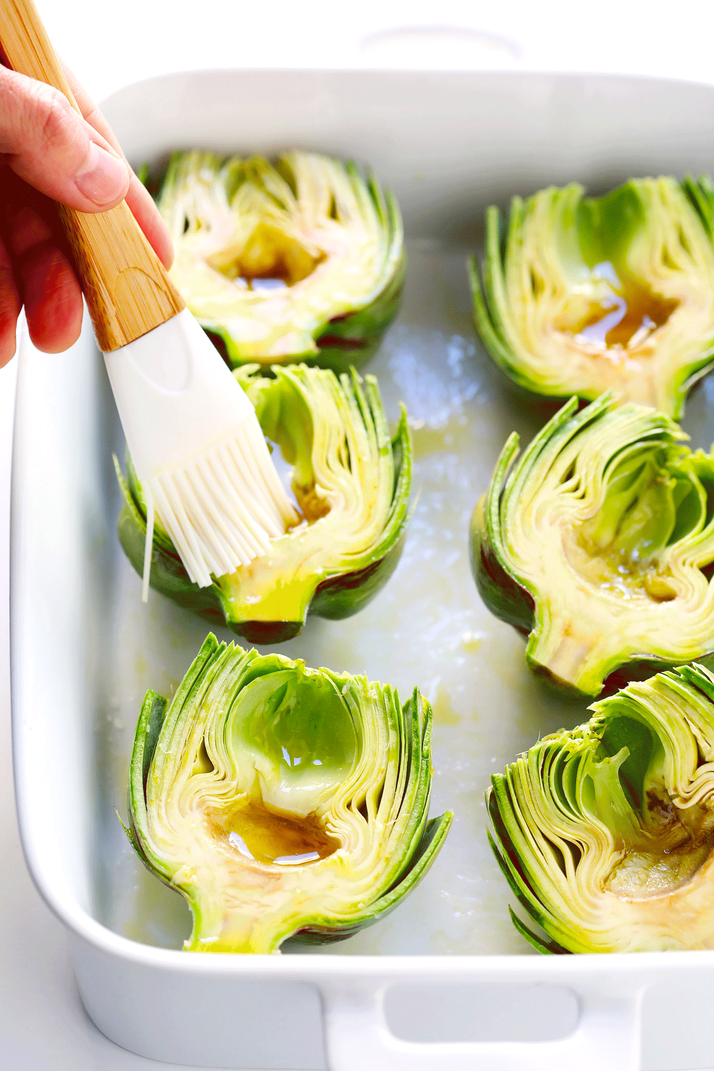 Seriously the most amazing roasted artichokes recipe! They're stuffed with lots of garlic and herbs, seasoned with lots of lemon and black pepper, and roasted to crispy, tender perfection. The perfect vegetable side dish! | Gimme Some Oven #artichokes #roasted #sidedish #vegetable #glutenfree #vegan How To Make Roasted Artichokes