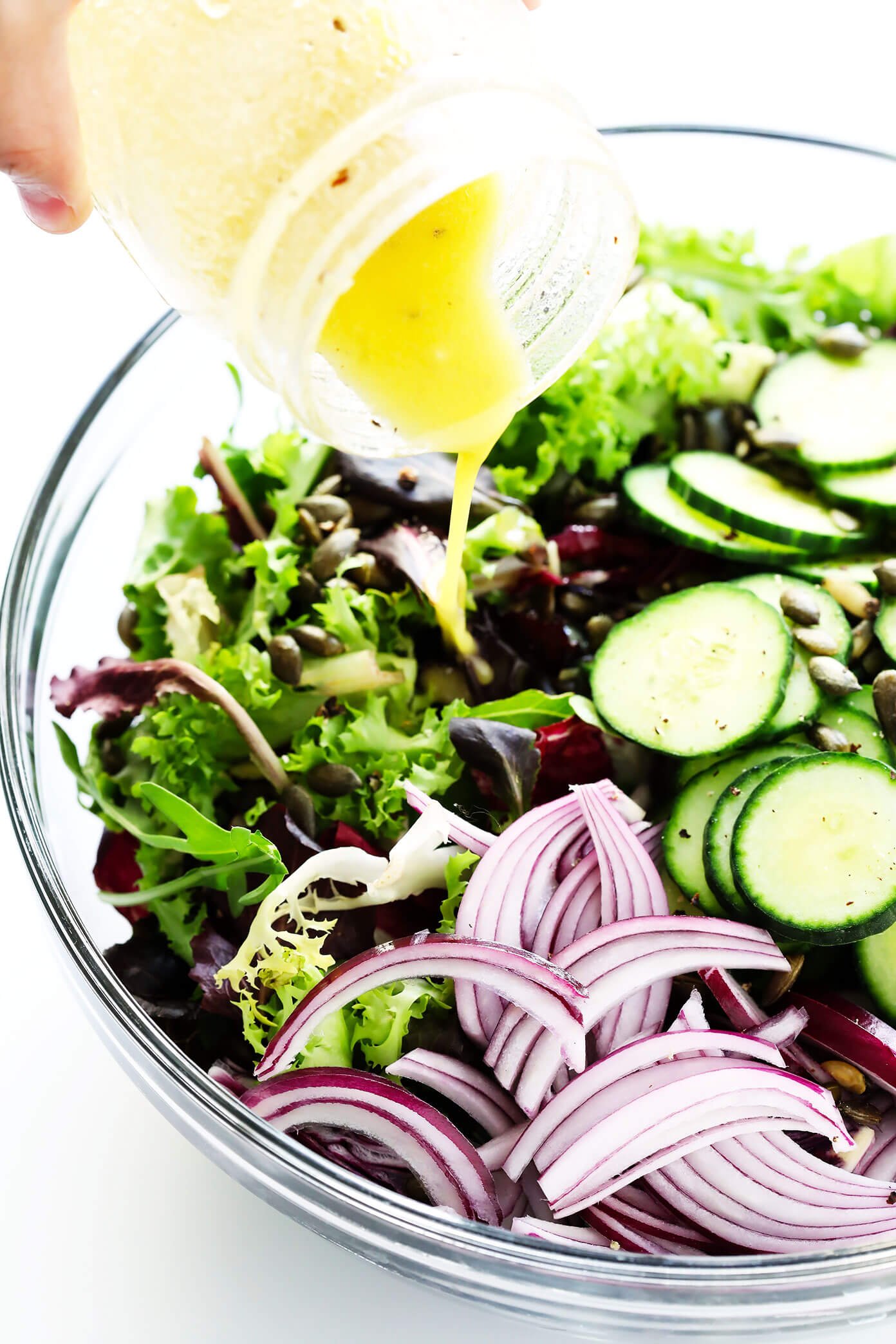 Adding salad dressing to salad bowl