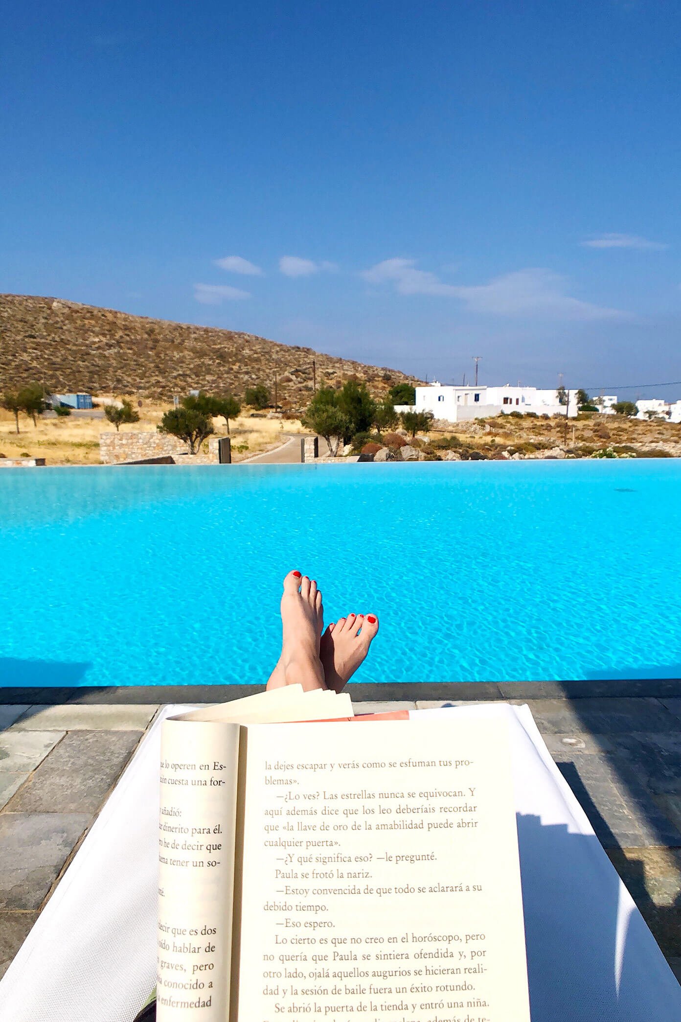 Reading by the pool at Anemi Hotel in Folegandros, Greece