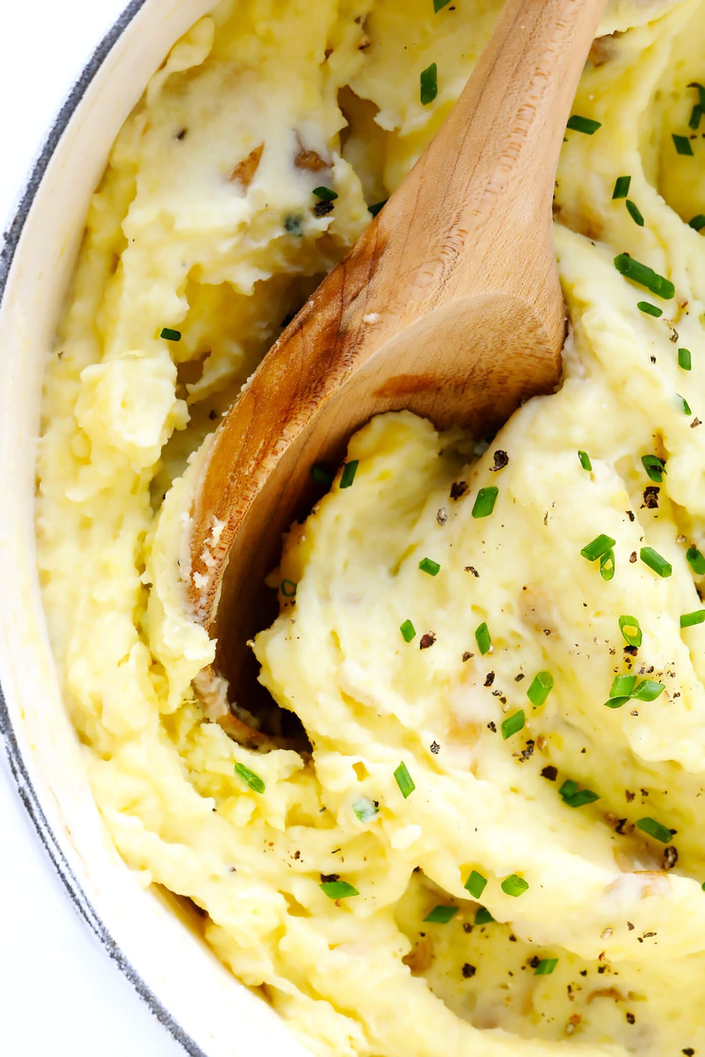 mashed potatoes in bowl with wooden spoon