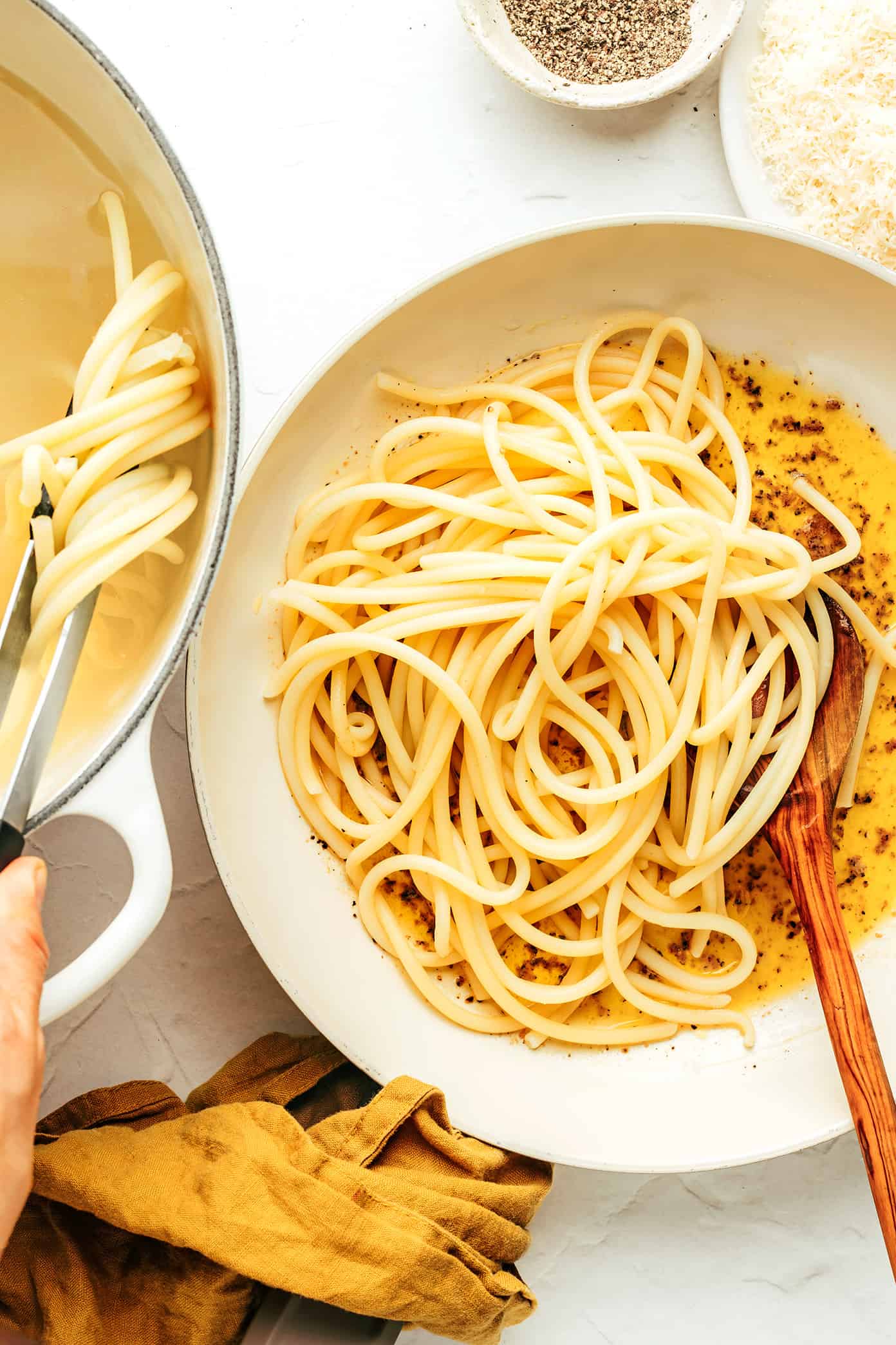 Mixing pasta into cacio e pepe sauce