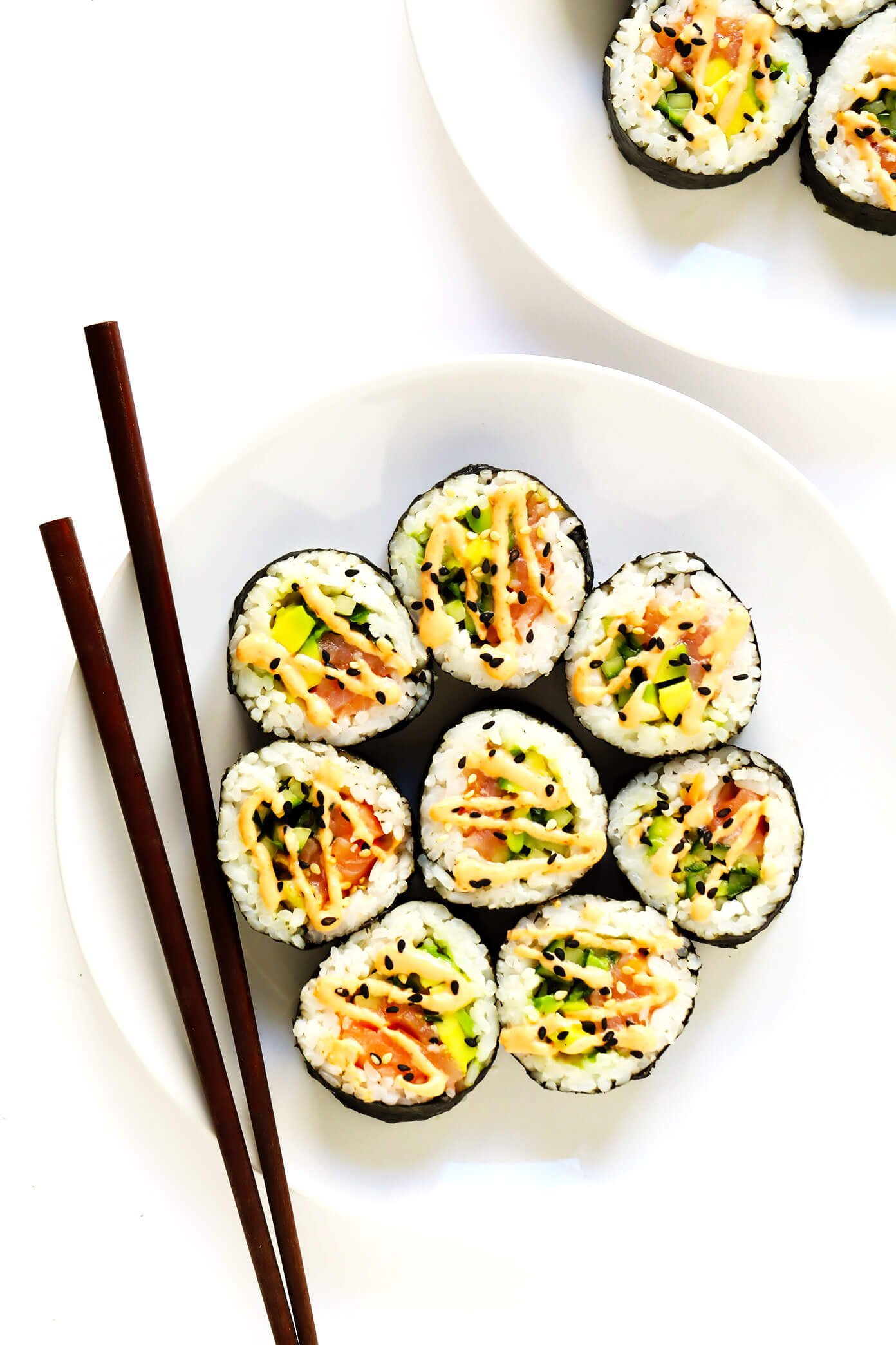 Plates of Spicy Salmon Avocado Maki Rolls with Chopsticks