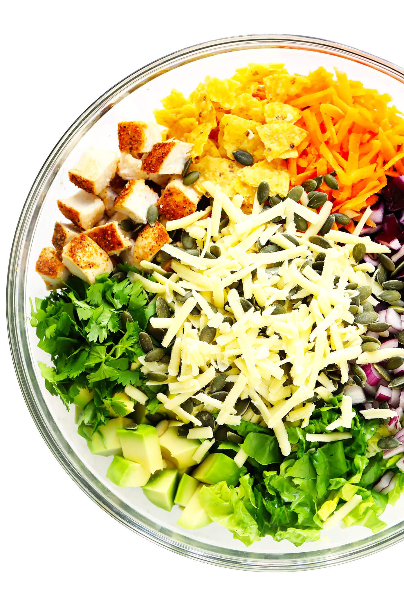 Bowl of Ingredients for Chipotle Chopped Salad -- Chicken, Tortilla Chips, Carrots, Cabbage, Red Onion, Romaine Lettuce, Cilantro, Baked Chicken, Cheddar Cheese and Pepitas