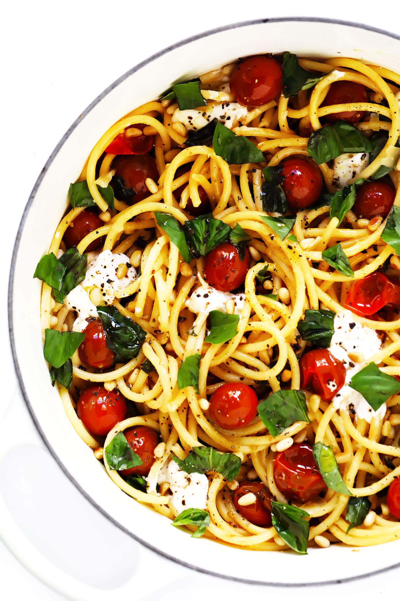 Pot of bucatini pasta with burrata cheese, cherry tomatoes, basil and pine nuts