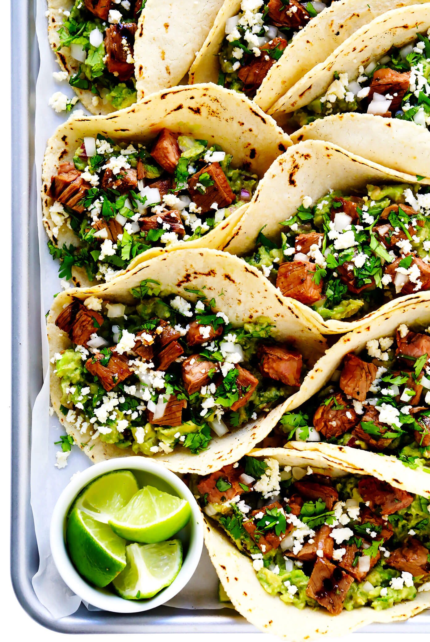 Bandeja de tacos de carne assada com limão, guacamole e queijo fresco