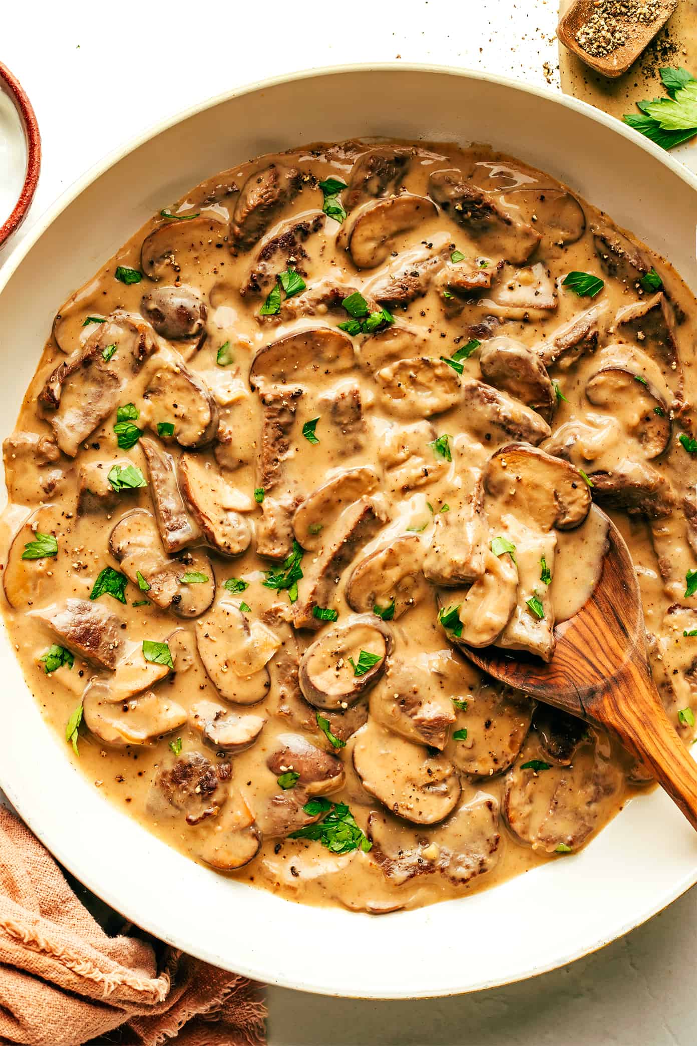 Beef Stroganoff in saute pan with wooden spoon