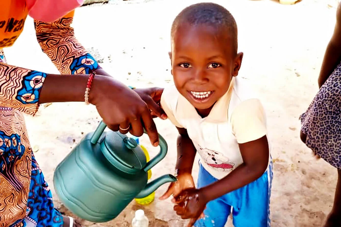 Menino em Mali lavando as mãos com sabão e água limpa