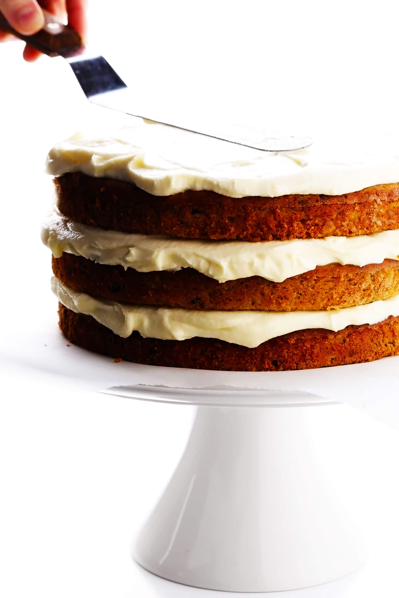 Assembling hummingbird cake layers with cream cheese frosting