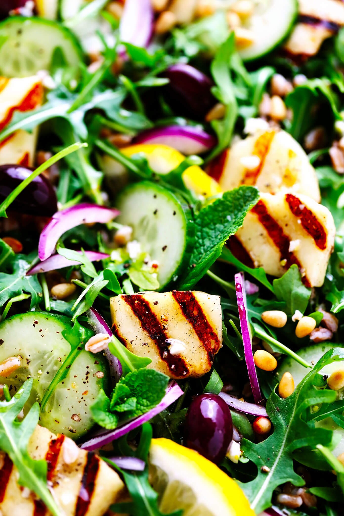 Closeup da salada de Halloumi grelhado com pepino, farro e pinhões