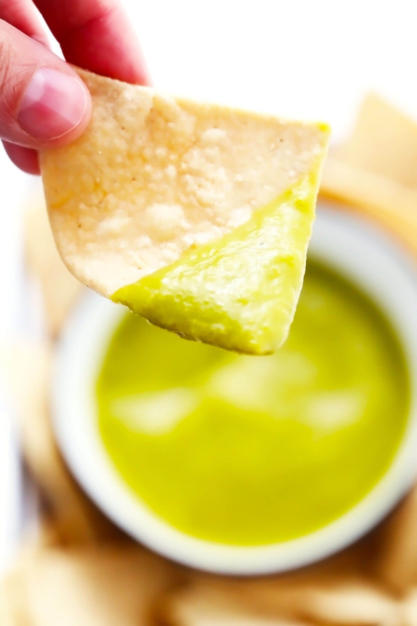 Scooping a tortilla chip in jalapeño salsa