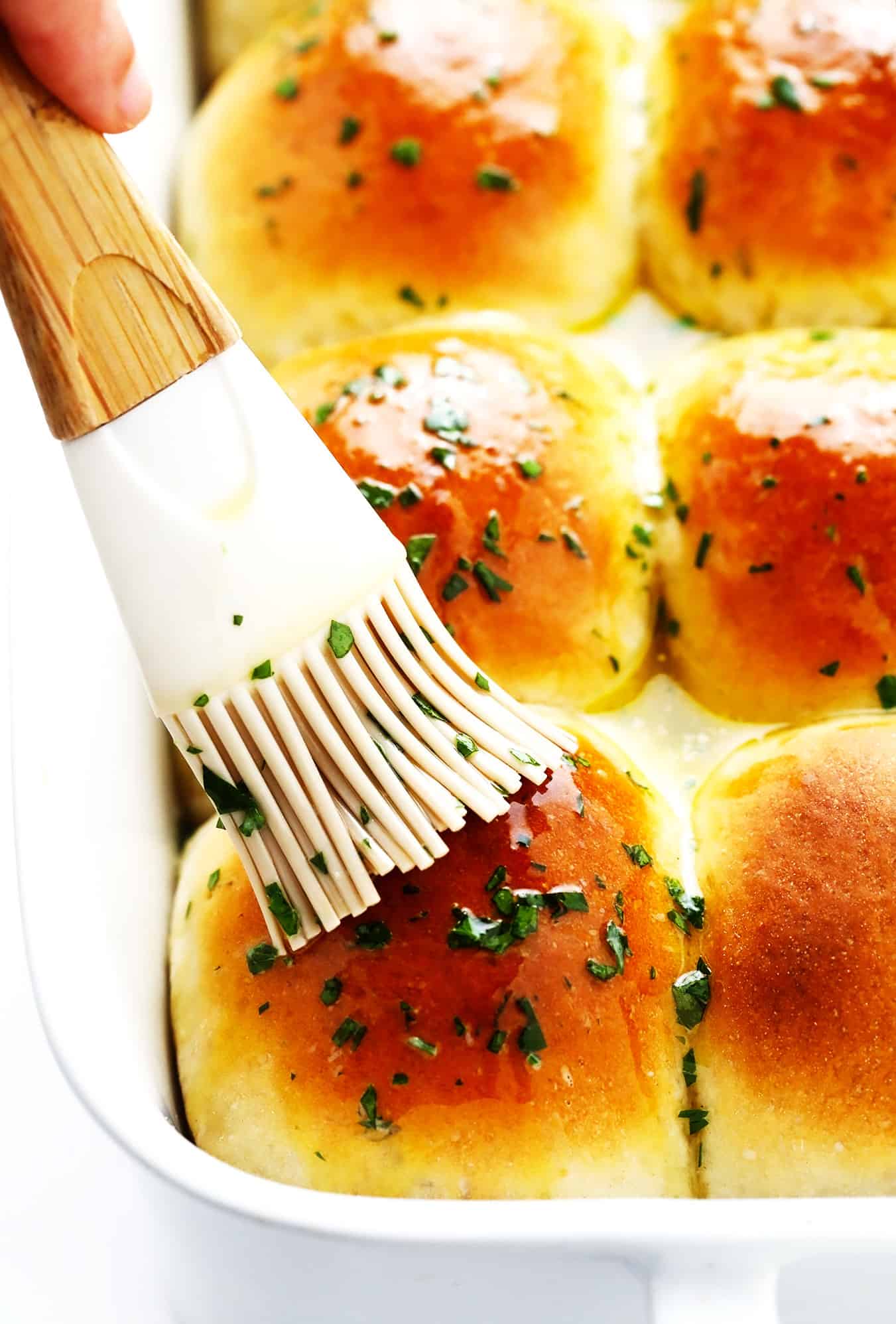 Brushing dinner rolls with garlic butter