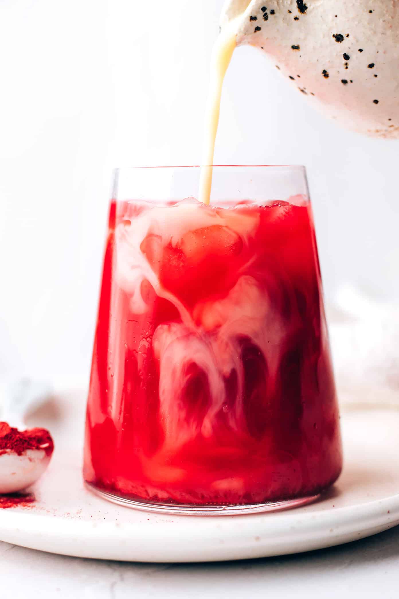 Pouring milk into an iced beetroot latte