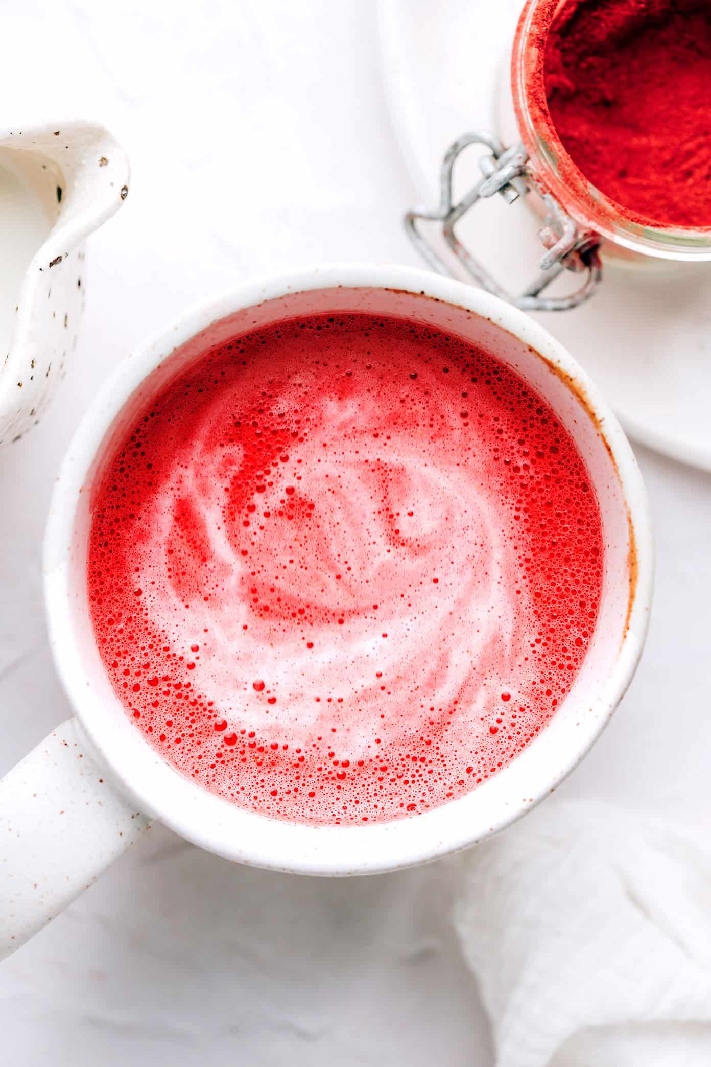 Café com leite rosa quente em uma caneca