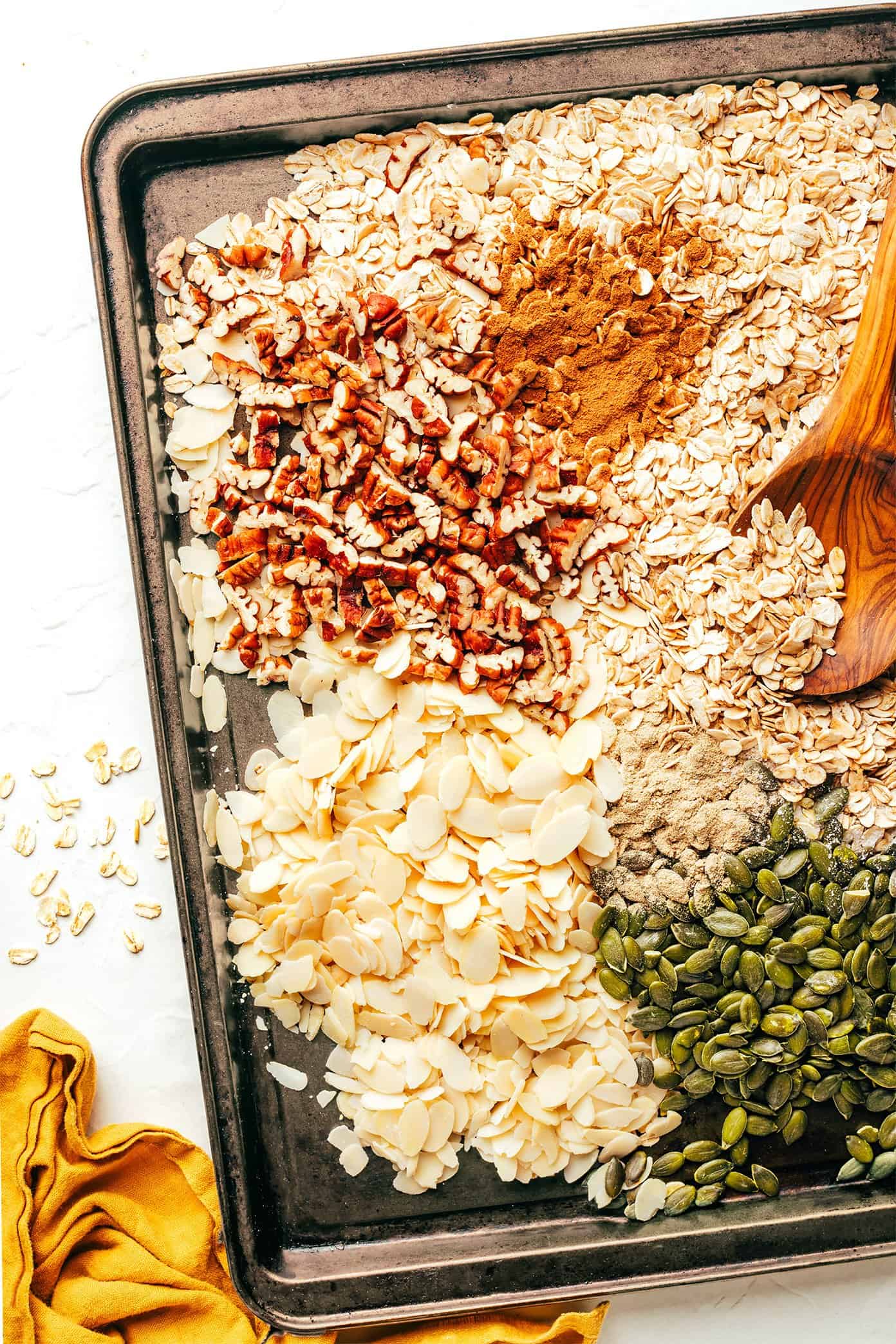 Muesli oats, nuts, and spices on baking sheet